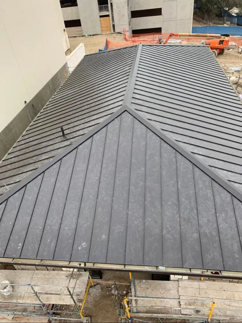 Commercial metal roof construction with crane equipment in McLean